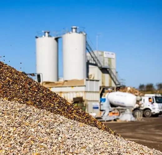 A pile of aggregates being offloaded by an R Collard lorry